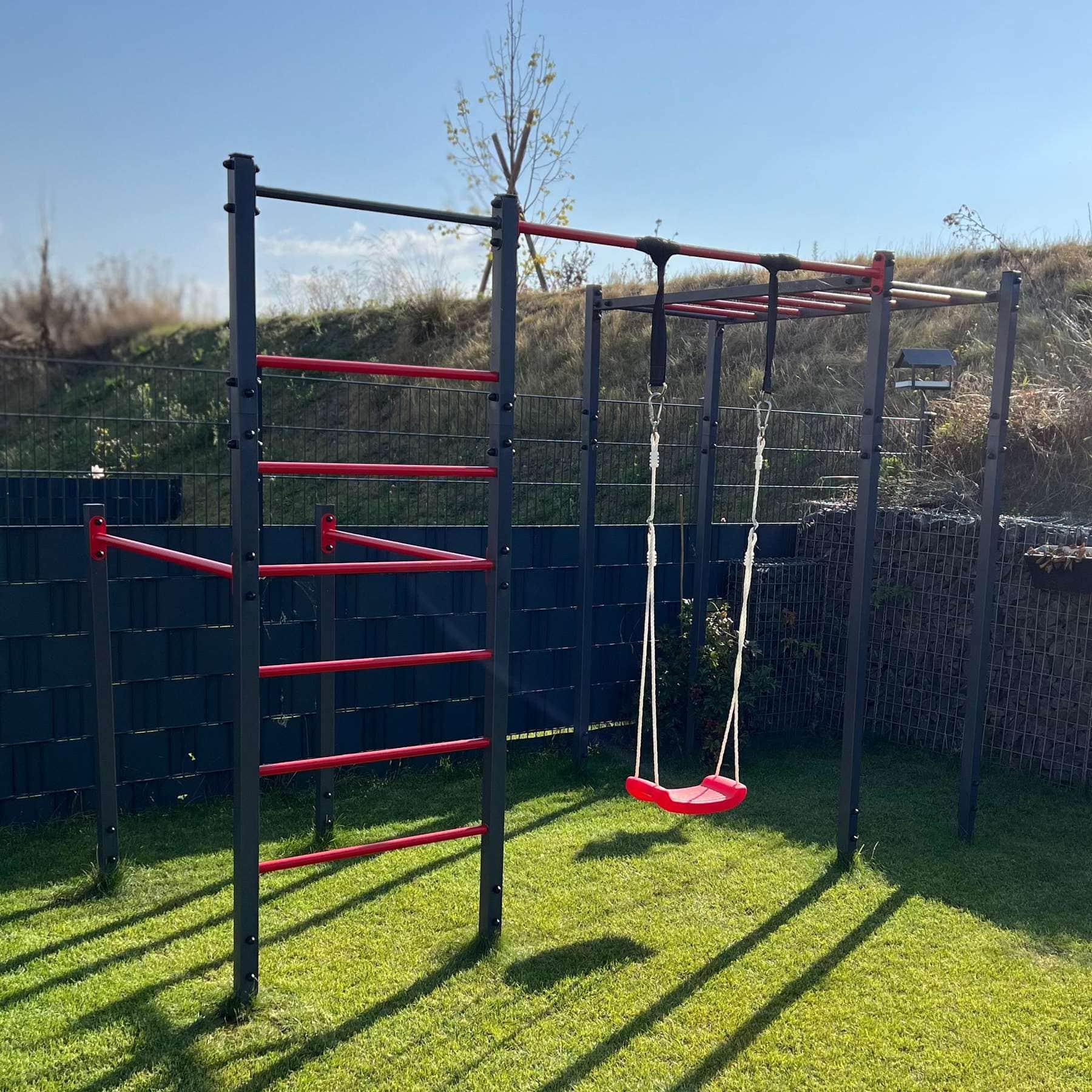 K-Sport Outdoor Calisthenics Station with Monkey Bars, Hanging Ladder, and Swing, set up in a garden